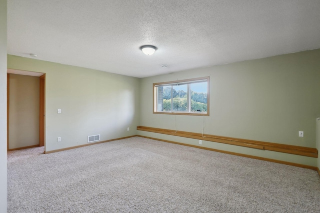 carpeted empty room featuring a textured ceiling