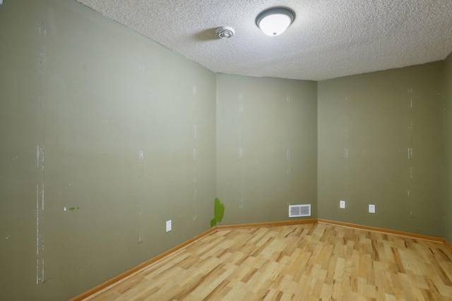 spare room with a textured ceiling and hardwood / wood-style flooring