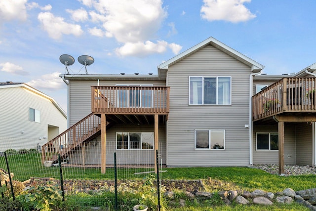 back of house featuring a wooden deck and a yard