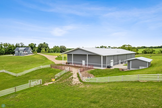 rear view of house featuring a yard and a rural view