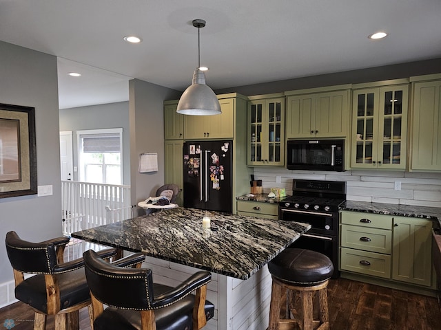 kitchen with green cabinets, decorative light fixtures, black appliances, dark wood-type flooring, and tasteful backsplash