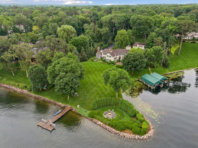 birds eye view of property with a view of trees and a water view