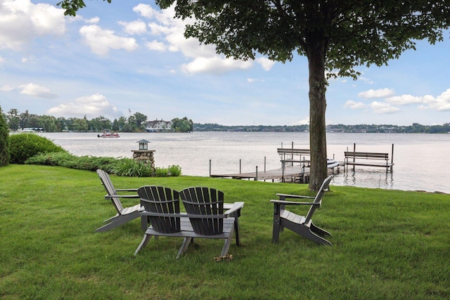 view of yard with a water view, boat lift, and a boat dock