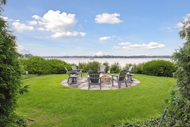 view of yard with a water view, a fire pit, and a patio area