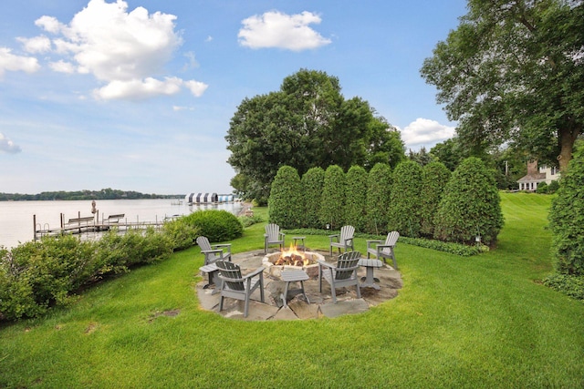 view of yard with a dock, a patio, a water view, and an outdoor fire pit