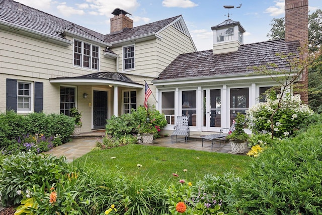 exterior space with a lawn, a chimney, and a patio area