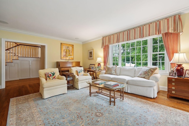 living area with stairs, baseboards, wood finished floors, and crown molding