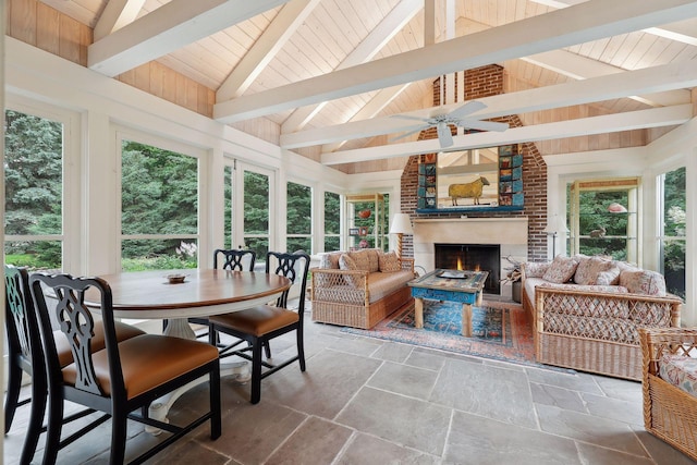 sunroom / solarium featuring lofted ceiling with beams, a brick fireplace, wooden ceiling, and a ceiling fan