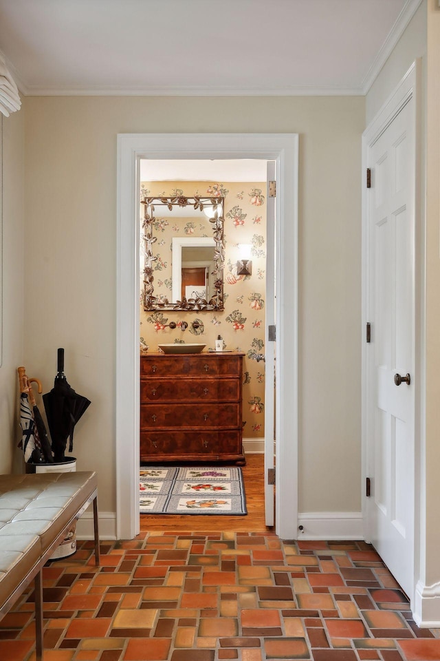 hallway featuring brick floor, baseboards, and ornamental molding