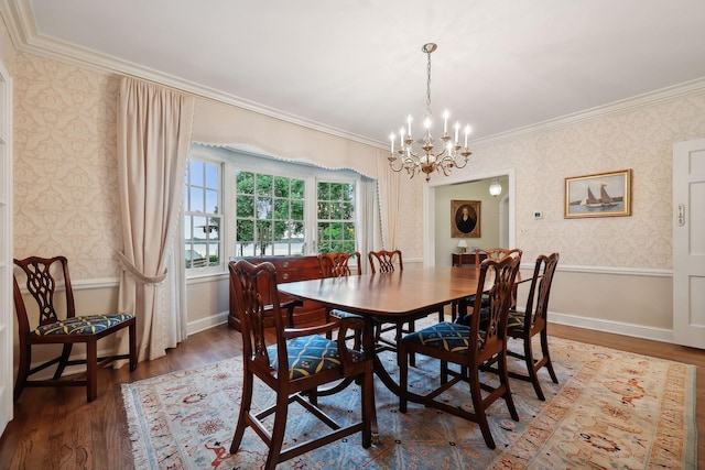 dining space featuring a chandelier, baseboards, wood finished floors, and wallpapered walls