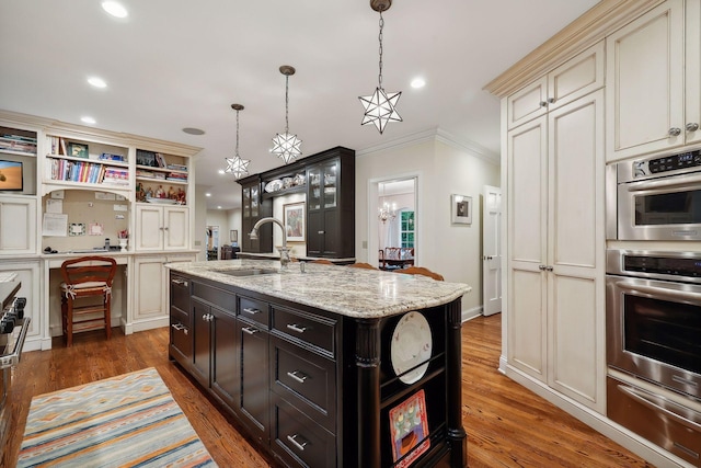 kitchen featuring open shelves, crown molding, light wood-type flooring, a warming drawer, and a sink