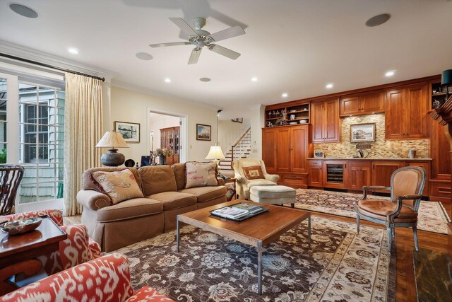 living room featuring wood finished floors, recessed lighting, ornamental molding, stairs, and wine cooler