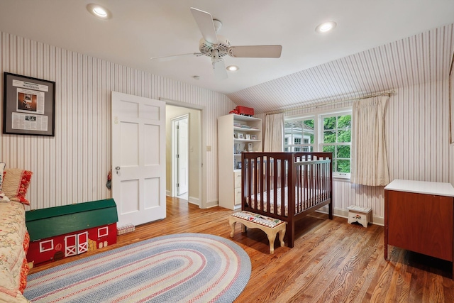 bedroom with light wood finished floors, recessed lighting, wallpapered walls, and vaulted ceiling