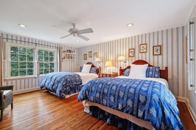 bedroom with wood finished floors, recessed lighting, wallpapered walls, baseboards, and ceiling fan