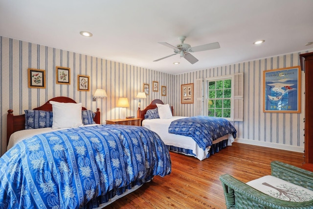 bedroom featuring wood finished floors, baseboards, a ceiling fan, wallpapered walls, and recessed lighting