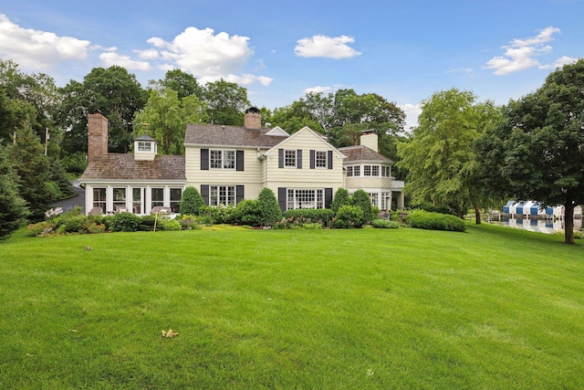 view of front of home featuring a chimney and a front yard