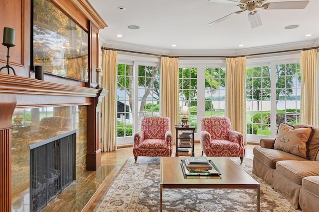 2670 Woolsey Ln, Woodland, MN 55391 - living room with crown molding, a ceiling fan, healthy amount of natural light, a premium fireplace, and wood finished floors