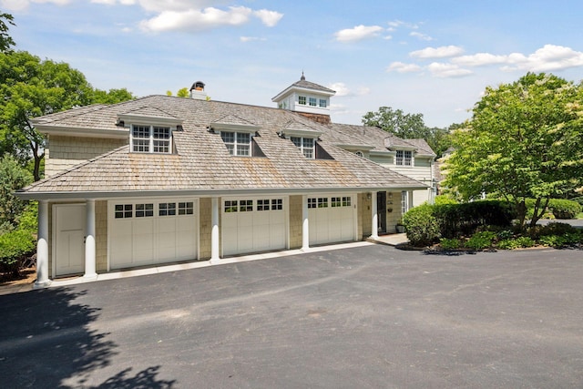 2670 Woolsey Ln, Woodland, MN 55391 - view of front facade featuring a garage and a chimney
