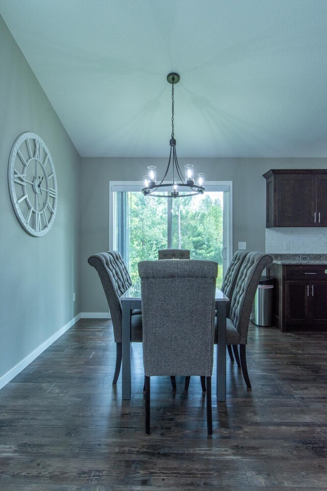 dining room with vaulted ceiling, dark hardwood / wood-style flooring, and a chandelier