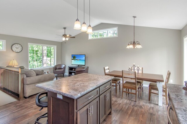 kitchen with ceiling fan with notable chandelier, vaulted ceiling, dark hardwood / wood-style flooring, and a wealth of natural light