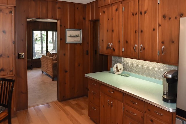 kitchen featuring wood walls, tasteful backsplash, and light hardwood / wood-style floors