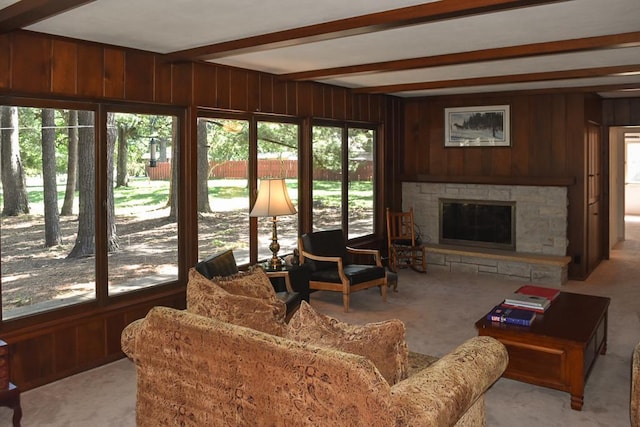 living room with a wealth of natural light, a fireplace, and beam ceiling