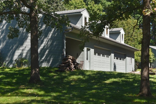 view of home's exterior with a garage and a lawn