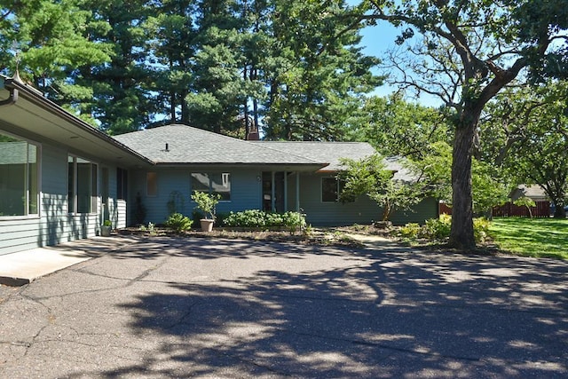 view of front of home with driveway and roof with shingles