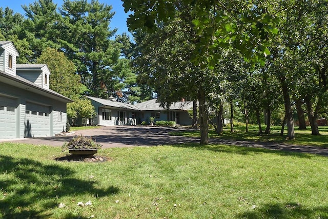 view of yard featuring driveway and a garage