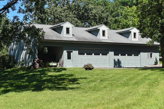 view of side of home featuring a garage, driveway, a shingled roof, and a yard