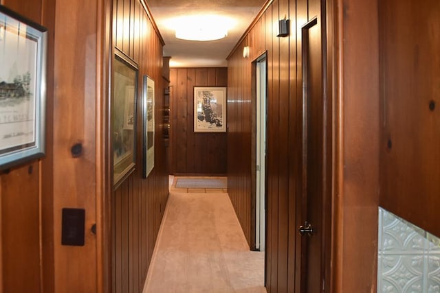 hallway featuring wood walls