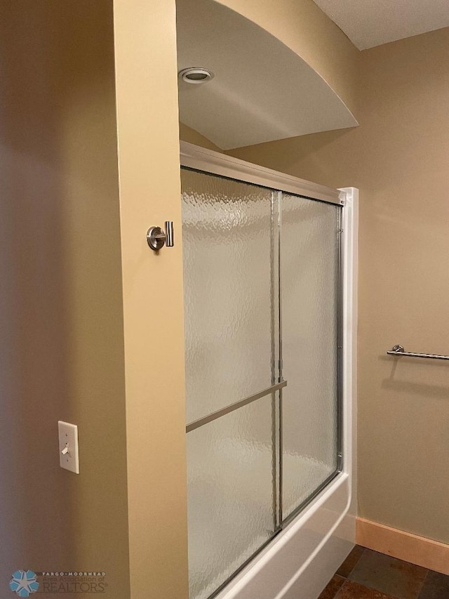 bathroom featuring tile patterned flooring and enclosed tub / shower combo