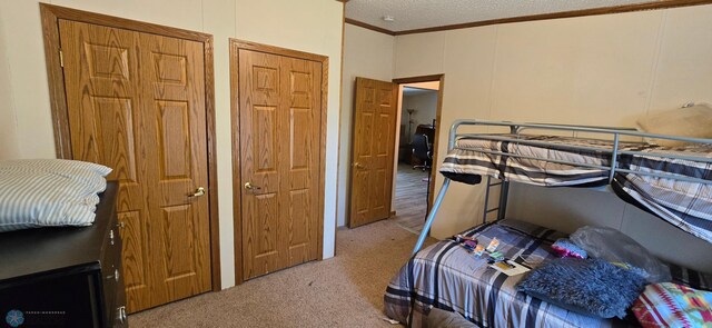 carpeted bedroom featuring a textured ceiling and ornamental molding