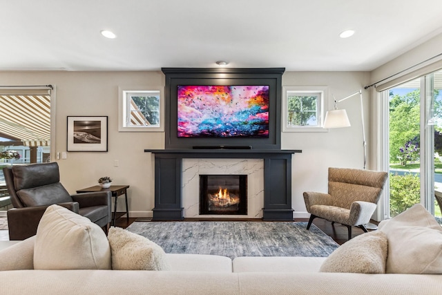 living area featuring a high end fireplace, plenty of natural light, baseboards, and recessed lighting