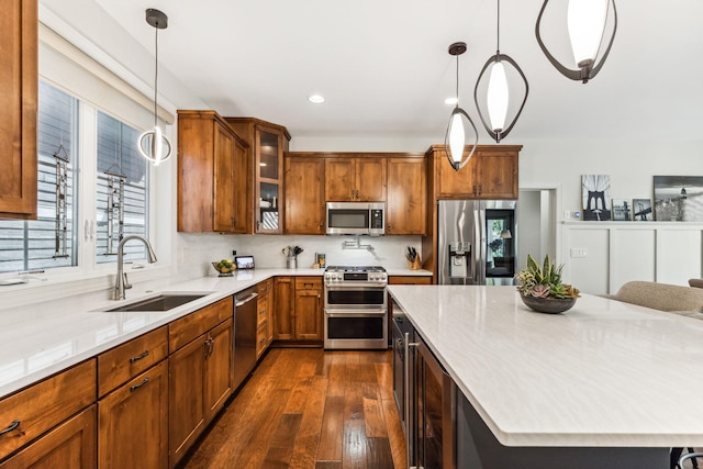 kitchen featuring pendant lighting, stainless steel appliances, dark hardwood / wood-style floors, and sink