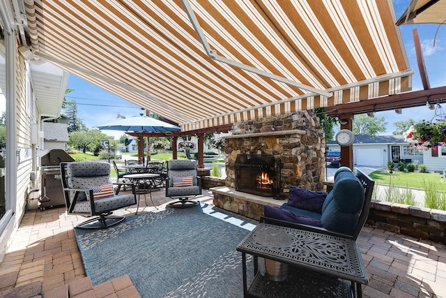 view of patio / terrace with an outdoor stone fireplace, grilling area, and outdoor dining space