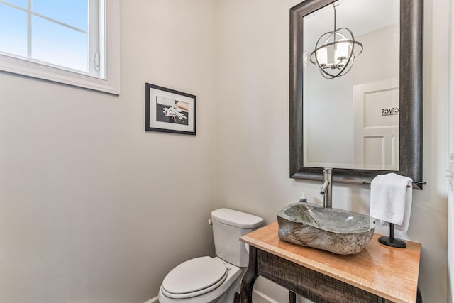 bathroom featuring baseboards, a sink, and toilet