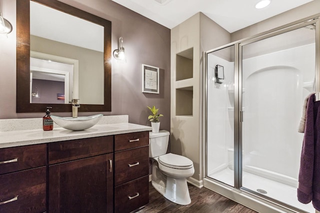 full bathroom with vanity, a shower stall, toilet, and wood finished floors