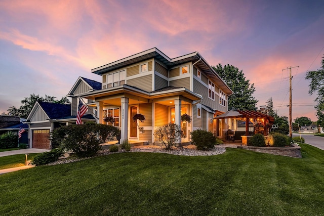 view of front of property featuring a garage, a porch, and a yard