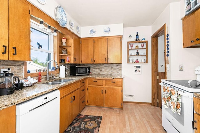 kitchen featuring decorative backsplash, white appliances, light hardwood / wood-style floors, and sink