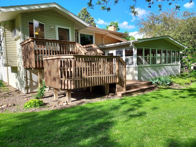 rear view of house featuring a deck, a lawn, and a sunroom