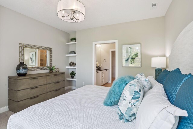 bedroom featuring a notable chandelier and ensuite bath