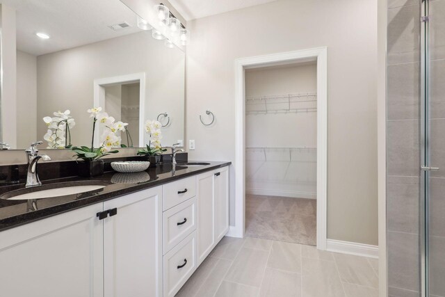 bathroom featuring vanity, walk in shower, and tile patterned flooring