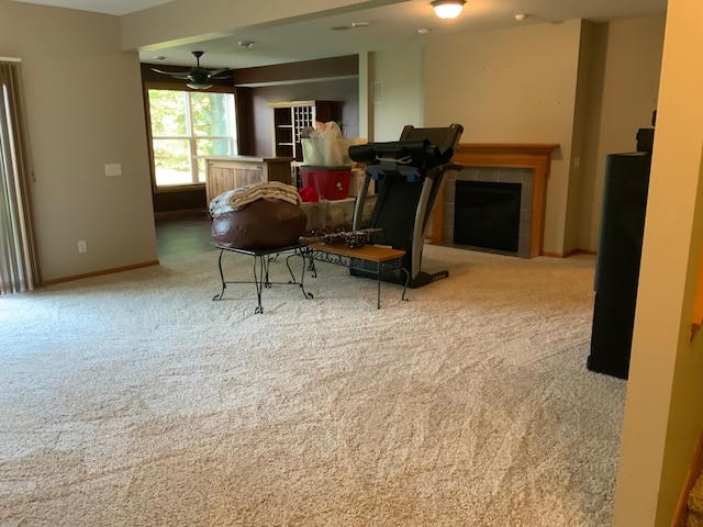 carpeted living room featuring ceiling fan and a fireplace