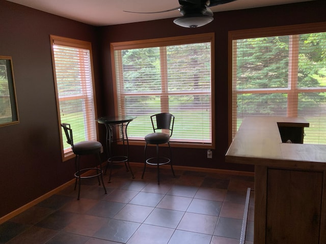 living area featuring tile patterned flooring, ceiling fan, and plenty of natural light