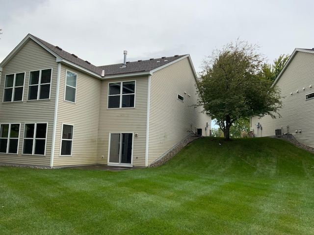 back of property with a lawn and central air condition unit