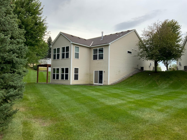 back of house featuring a lawn and a wooden deck