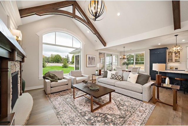 living room featuring dark hardwood / wood-style floors, a fireplace, beam ceiling, and an inviting chandelier