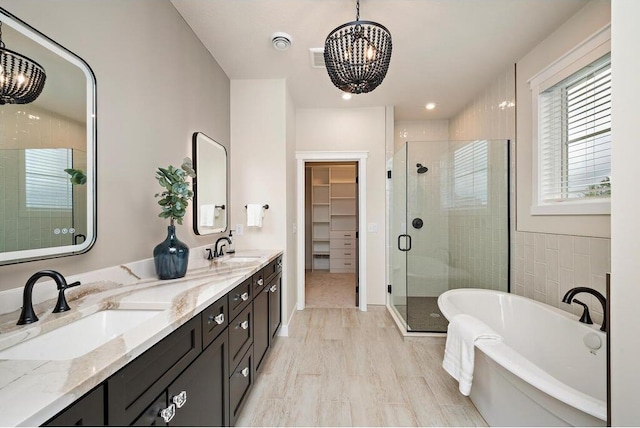 bathroom featuring an inviting chandelier, wood-type flooring, independent shower and bath, and vanity