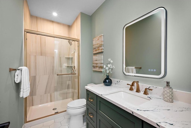 bathroom with tile patterned flooring, a shower with door, vanity, and toilet